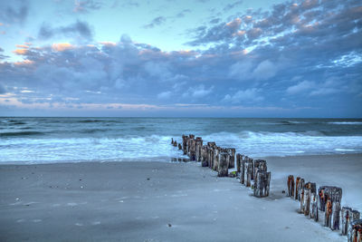 Dawn over a dilapidated pier on the beach in port royal in naples, florida.