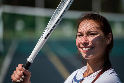 Close-up portrait of a smiling woman holding outdoors