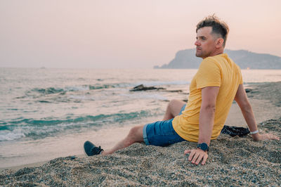 Portrait of young man standing at beach