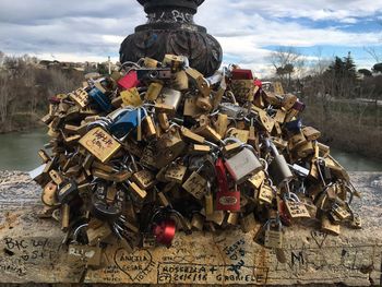 Close-up of padlocks hanging on metal against sky