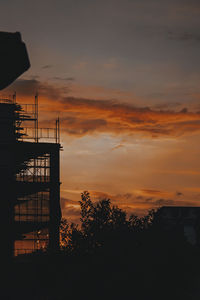 Silhouette trees against orange sky