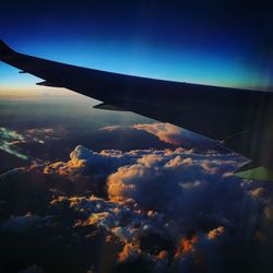 Close-up of airplane wing against blue sky