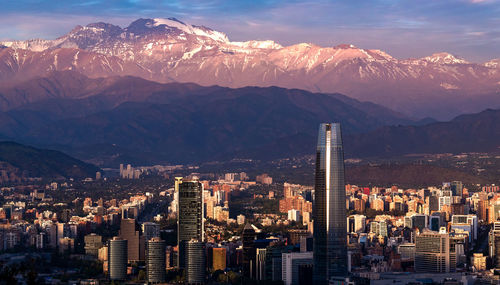 Aerial view of buildings against mountains in city during winter