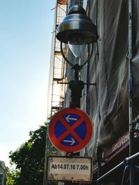 Low angle view of road sign against blue sky