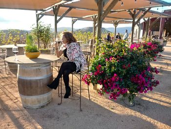 Woman sitting by flower pots