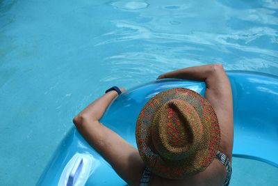 High angle view of woman on inflatable in swimming pool