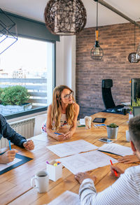 Businesswoman in a work meeting looking at construction drawings of a house