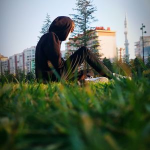 Man relaxing on grass against sky