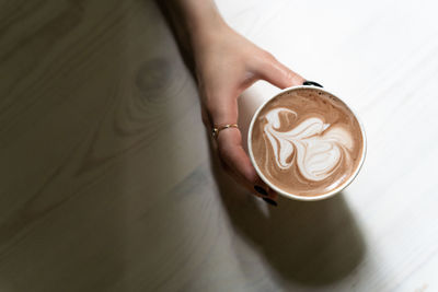 Top view of female hand holding cup of hot cocoa drink
