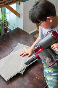 High angle view of boy cleaning on table