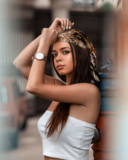 Portrait of young woman wearing bandana standing outdoors