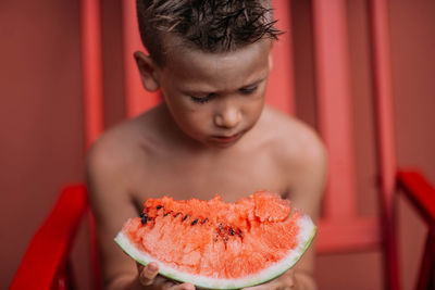 Portrait of boy holding red chili pepper