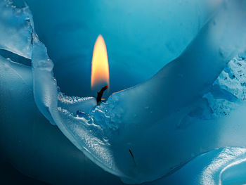 Close-up of lit candle in water