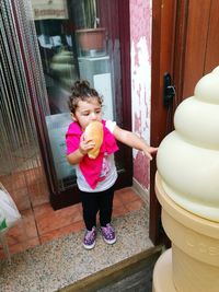 Full length of cute girl holding pink flower