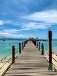 Wooden pier over sea against sky