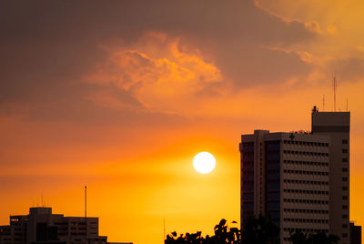 Silhouette buildings against sky during sunset