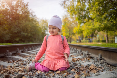 Cute girl standing on railroad track