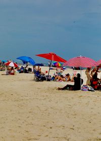 Group of people on beach against the sky