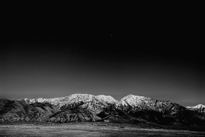 Scenic view of snowcapped mountains against clear sky at night