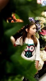 Beautiful woman standing by flowering plant