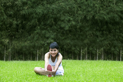 Portrait of woman doing yoga on field