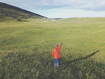 Rear view of boy standing on field