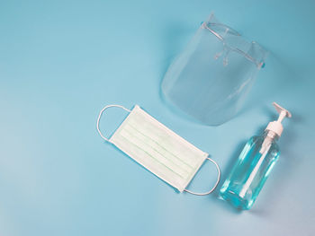 High angle view of drinking glass on table against blue background