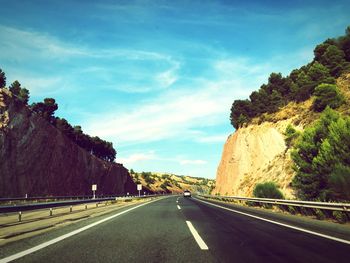 Road amidst trees against sky