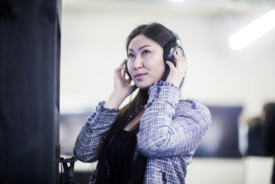 Young asia woman with paper in an office with headphone