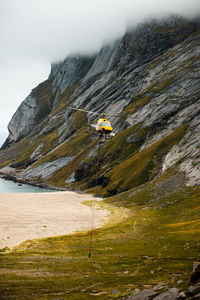 Scenic view of helicopter soaring by cloud-covered mountain. ideal for adventure projects.