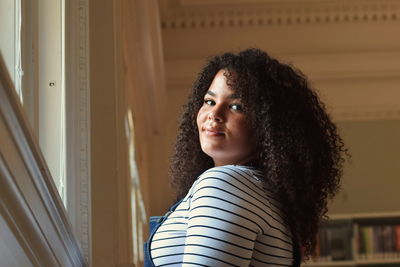 Portrait of beautiful young woman standing at home