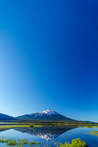 Scenic view of mt bachelor and sparks lake against clear blue sky