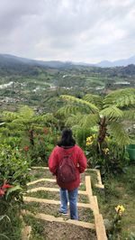 Rear view of woman walking on mountain against sky