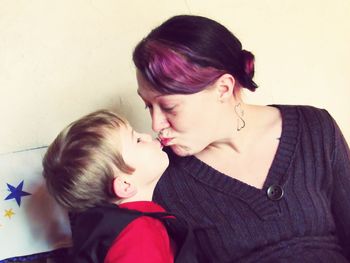 Mother and son kissing at home
