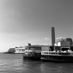 Ship in sea against buildings in city against sky