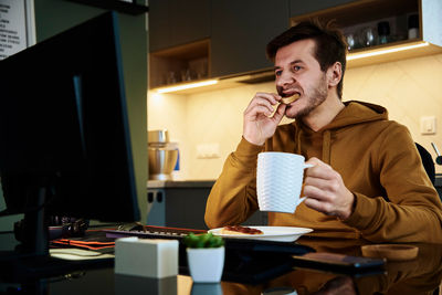 Tired man works late at workplace, use computer