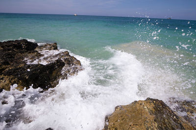 Scenic view of rocks on sea against sky