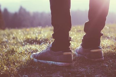 Low section of man standing on field