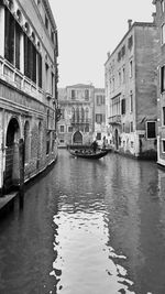 Canal amidst buildings against sky in city