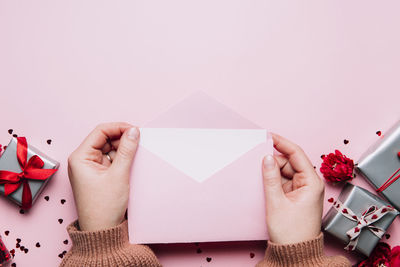 Midsection of woman holding gift box against white background