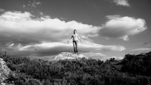 Woman standing on rock amidst plants