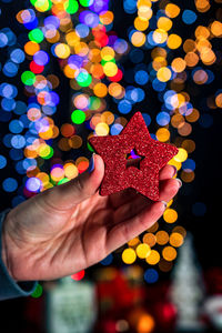 Midsection of person holding illuminated christmas decorations