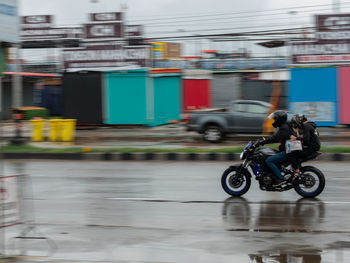 Blurred motion of man riding bicycle on street