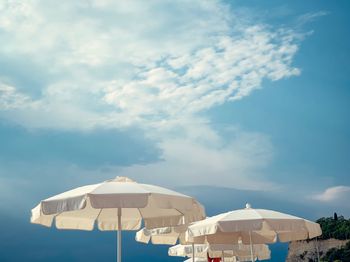 Low angle view of parasols against sky