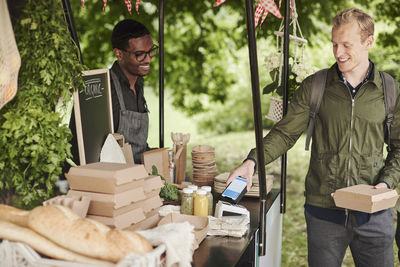 Man paying with cell phone at food stall