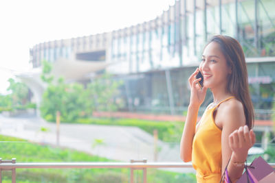 Smiling young woman using mobile phone