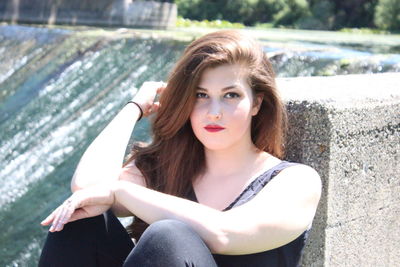 Portrait of young woman sitting outdoors