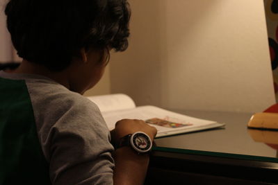 Close-up of boy reading book at home