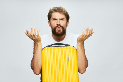 Portrait of young man standing against white background