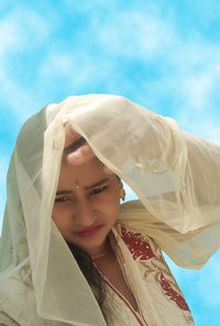 Portrait of beautiful woman standing against sky